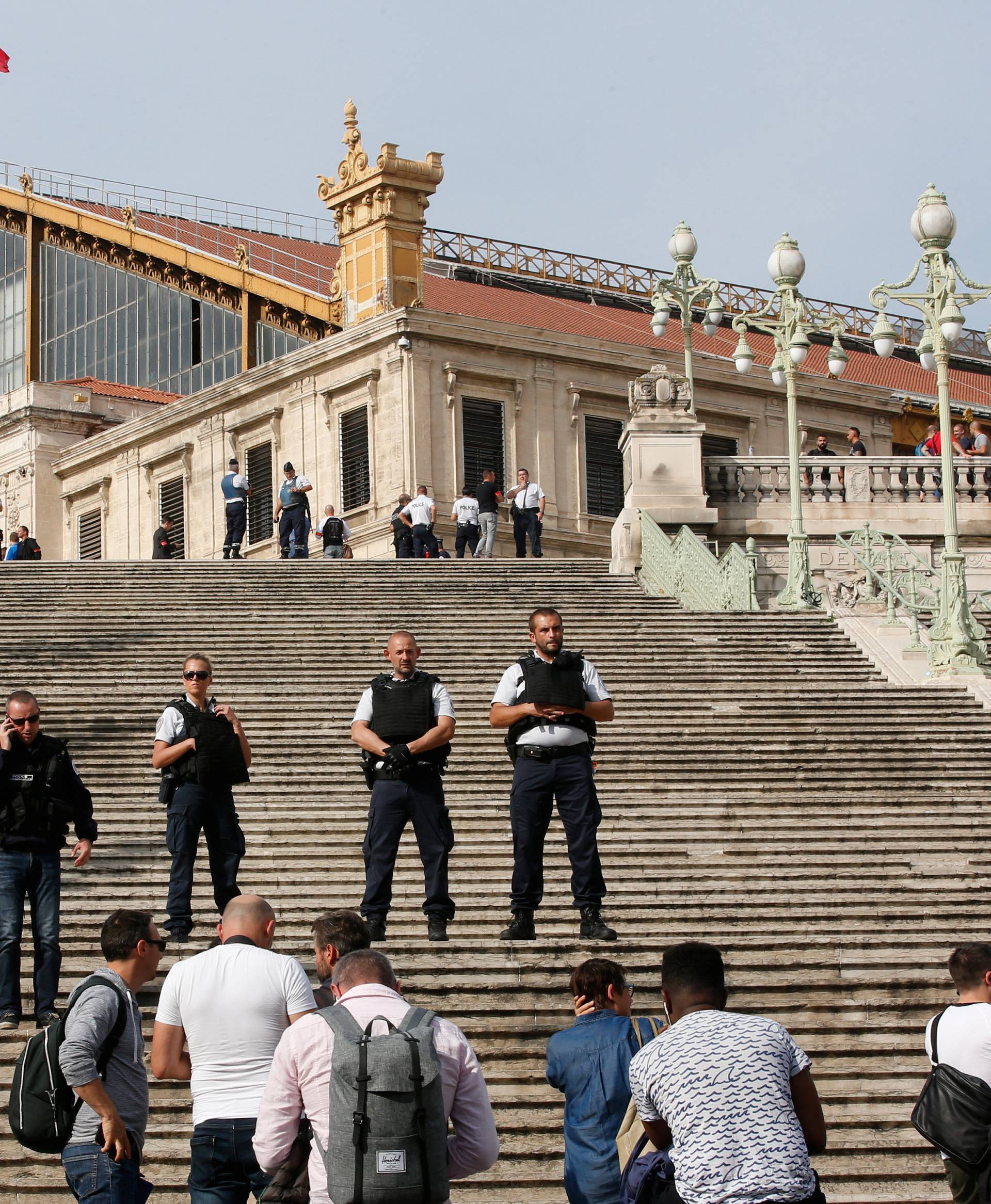 Police keep people at a distance as they secure the access to the Saint-Charles train station after French soldiers shot and killed a man who stabbed two women to death at the main train station in Marseille