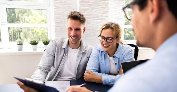 Financial,Consultant,Explaining,New,Project,Investment,To,Young,Couple,In