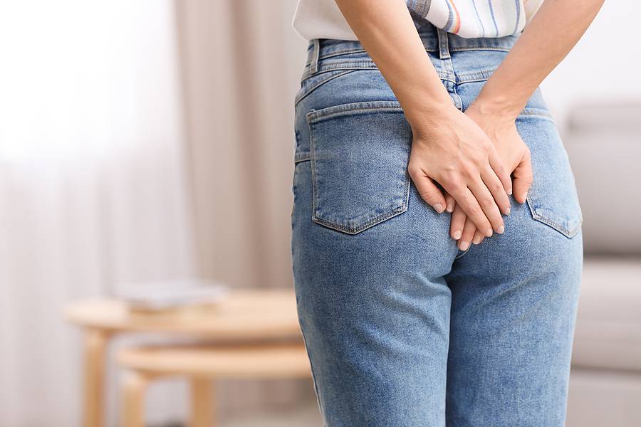 Young Woman Suffering From Hemorrhoid At Home, Closeup