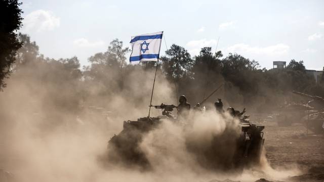 An Israeli Armoured Personnel Carrier (APC) takes position near Israel's border with the Gaza Strip