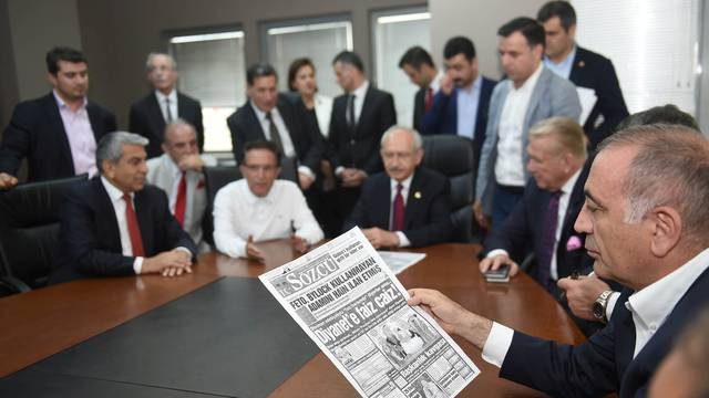 Gursel Tekin, a lawmaker from the main opposition Republican People's Party (CHP) holds a print copy of Sozcu daily newspaper as they visit the publication's headquarters in Istanbul