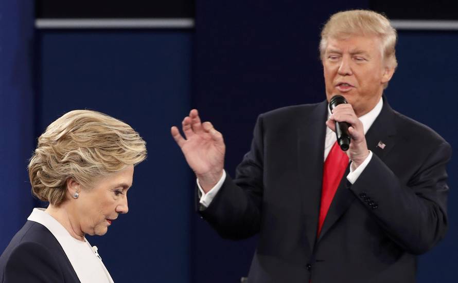 Republican U.S. presidential nominee Trump speaks as Democratic U.S. presidential nominee Clinton listens during their presidential town hall debate in St. Louis