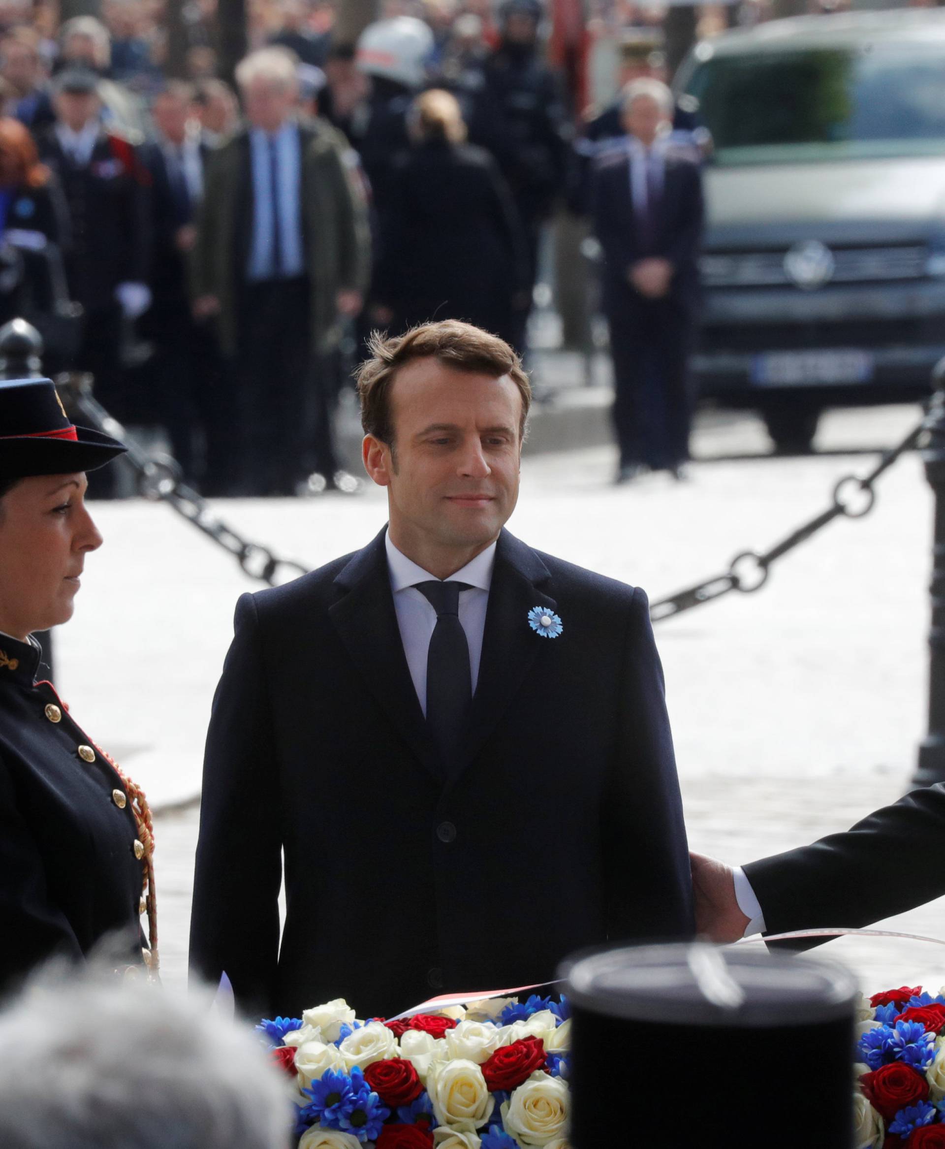 Outgoing French President Francois Hollande and President-elect Emmanuel Macron attend a ceremony to mark the end of World War II at the Tomb of the Unknown Soldier at the Arc de Triomphe in Paris