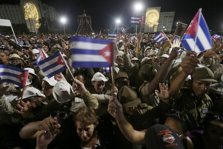 People wave Cuban flags as they attend a massive tribute to Cuba's late President Fidel Castro in Revolution Square in Havana