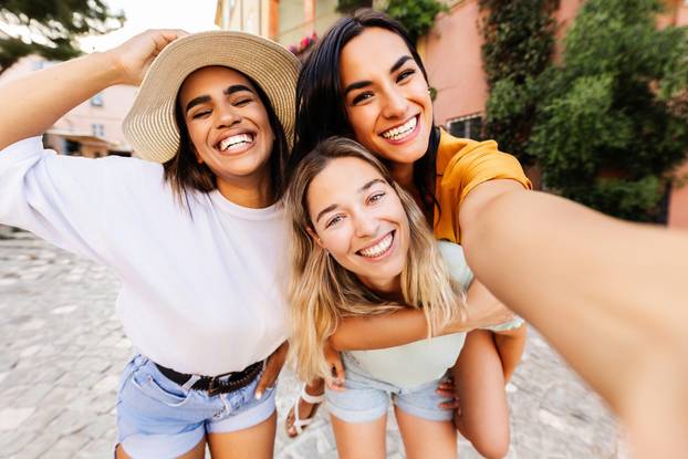 Diverse group of three happy young women having fun on summer vacation