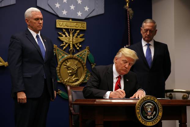 U.S. President Donald Trump signs an executive order he said would impose tighter vetting to prevent foreign terrorists from entering the United States at the Pentagon in Washington