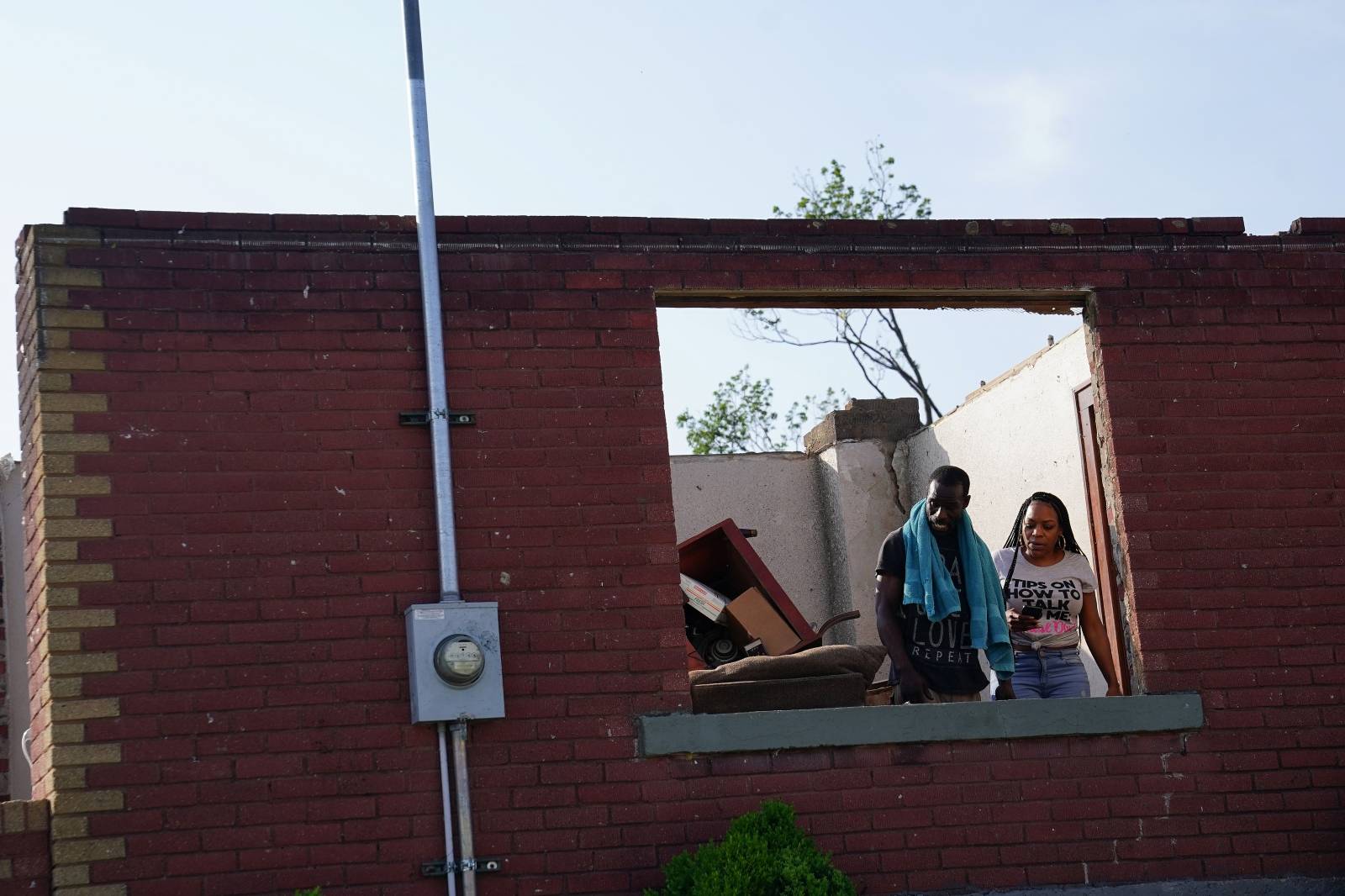 People look out a window of a destroyed home, following a tornado in Jefferson City