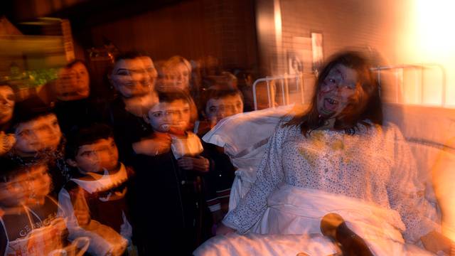 A woman dressed up as a character from the movie "The Exorcist" reacts during Halloween in La Fresneda