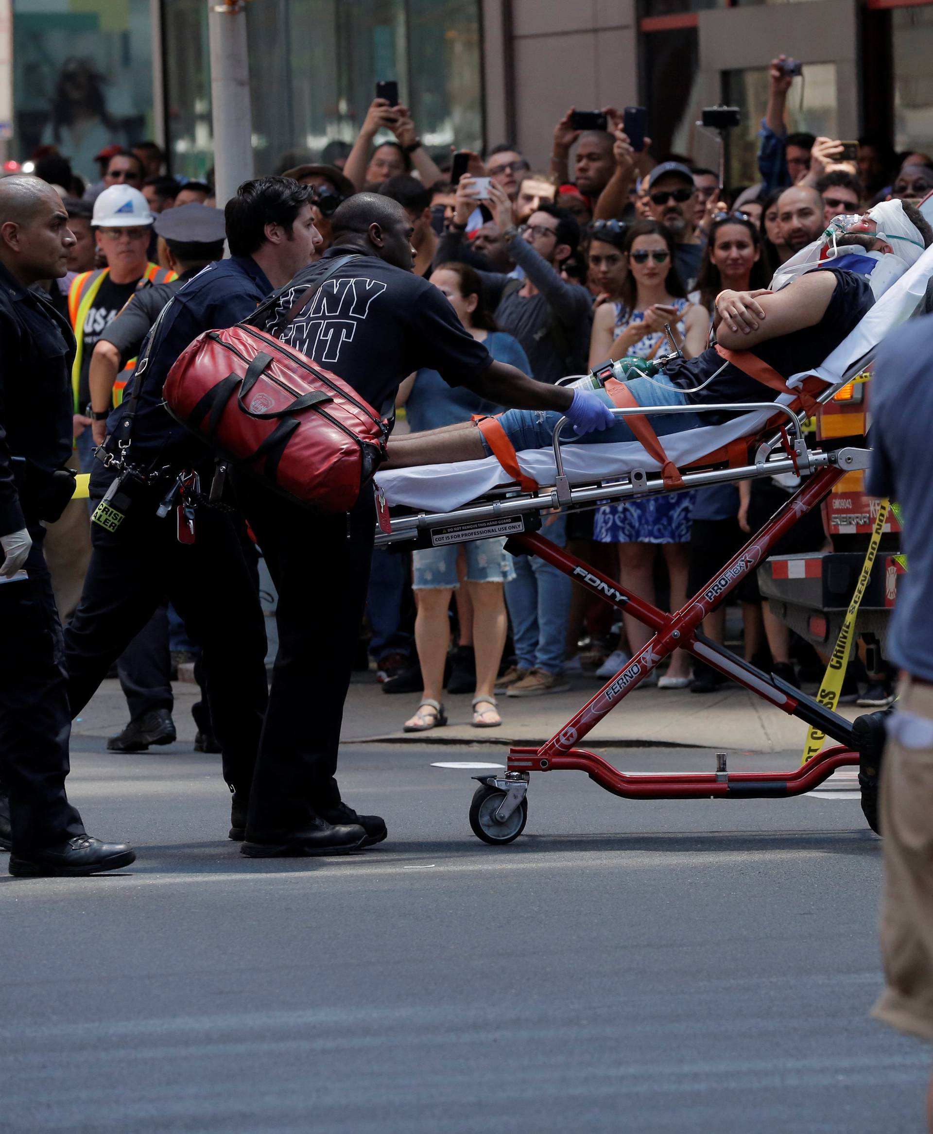 First responders tend to an injured pedestrian after a vehicle struck pedestrians on a sidewalk in Times Square in New York