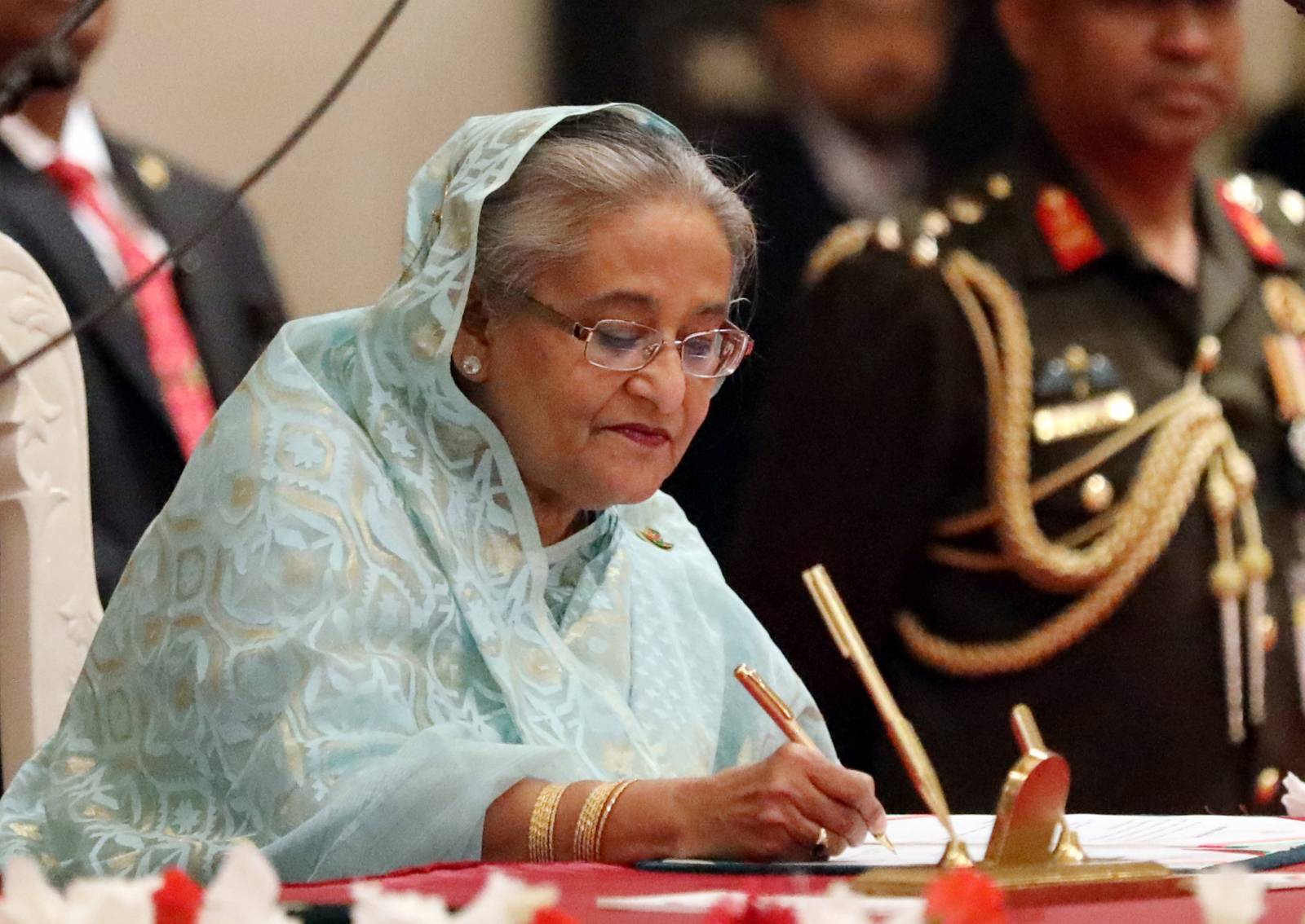 Sheikh Hasina signs the official oath book after taking oath as the Prime Minister for the third consecutive time in Dhaka