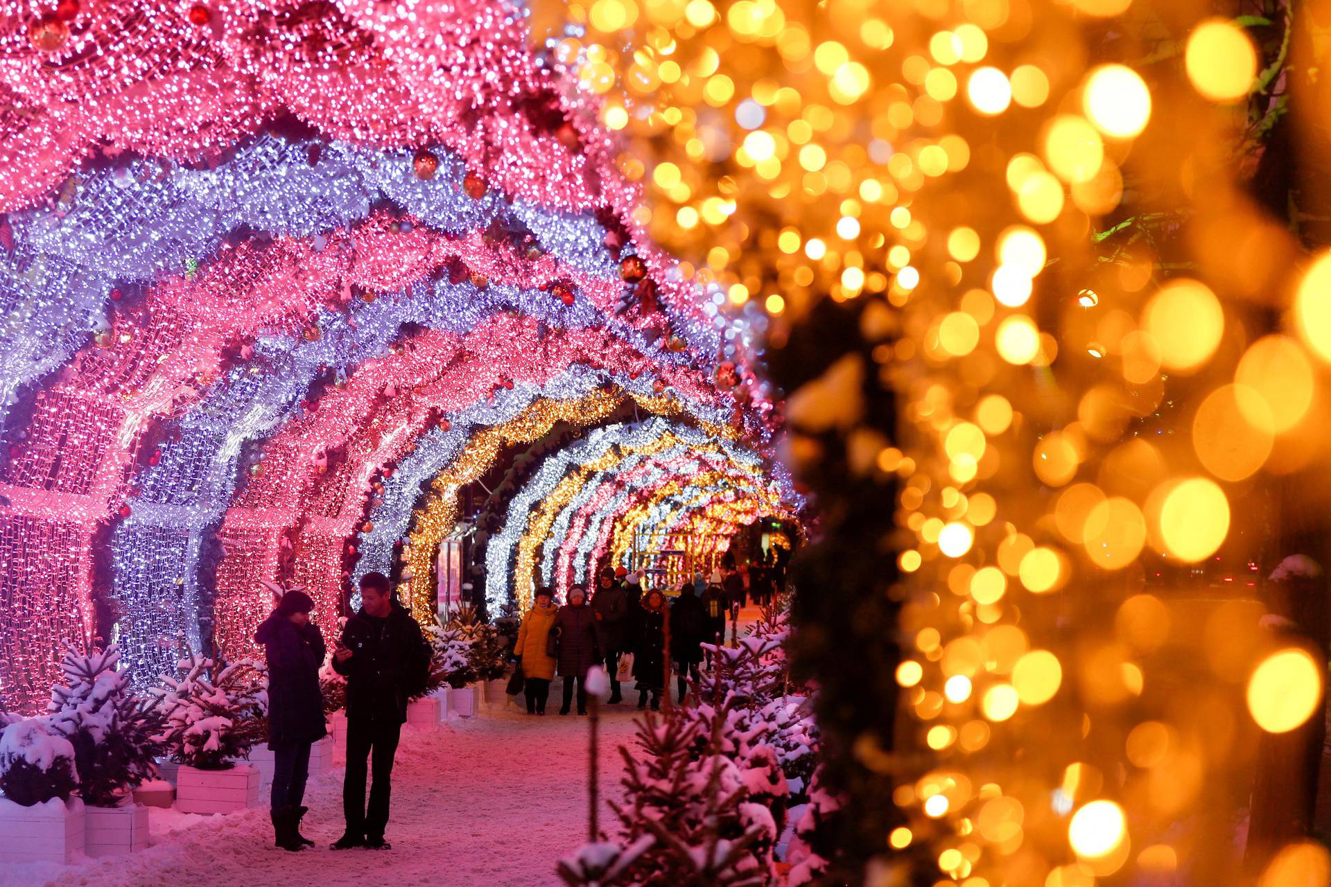 People walk through illuminated decorations in central Moscow