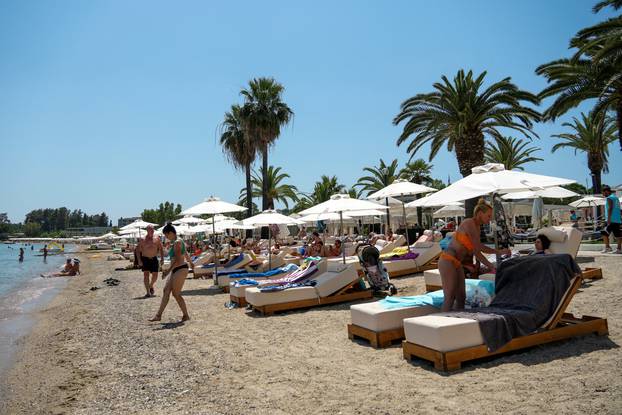 FILE PHOTO: People visit Dassia beach on the island of Corfu