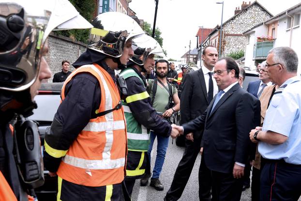 French President Francois Hollande shakes hands with French firemen as he arrives after a hostage-taking at a church in Saint-Etienne-du-Rouvray