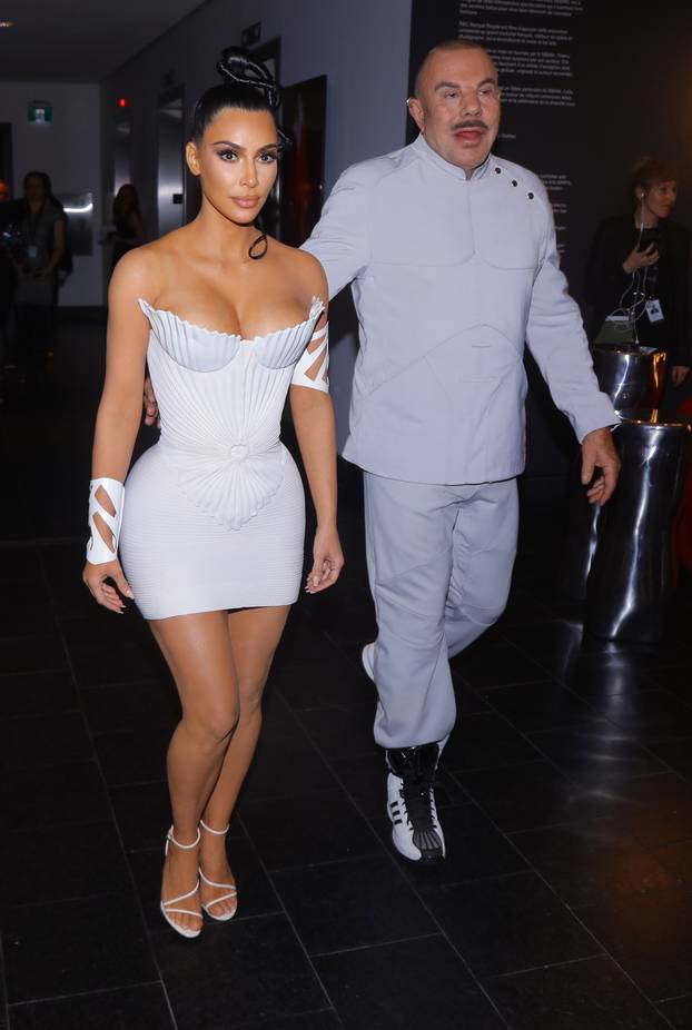Kim Kardashian shows off her figure in a stylish all white dress and stuns while looking inside at the Thierry Mugler exhibition opening night in Montreal Canada