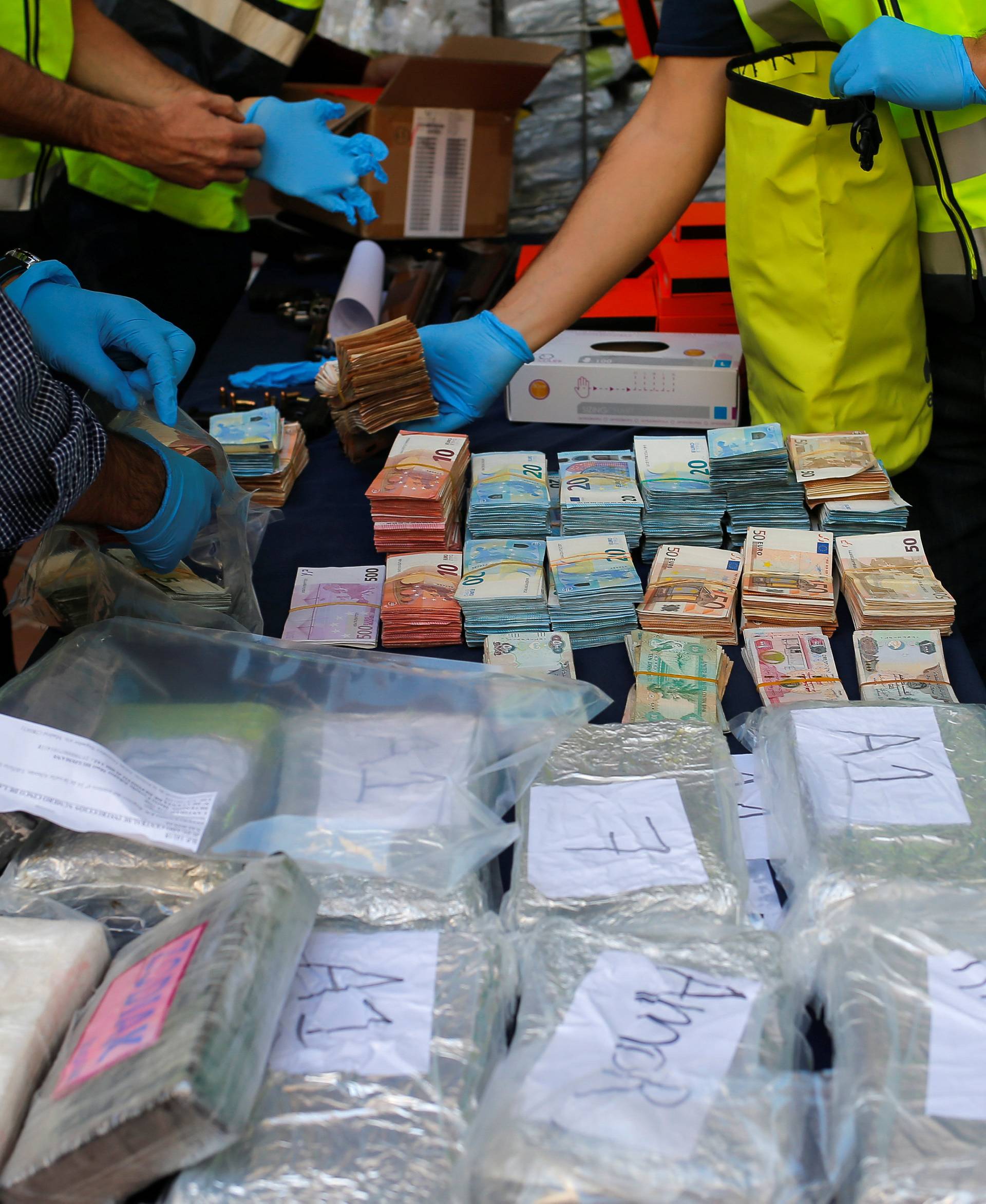 Police display a portion of the six tonnes of cocaine, money and other material seized at an industrial estate at the police headquarters in Malaga