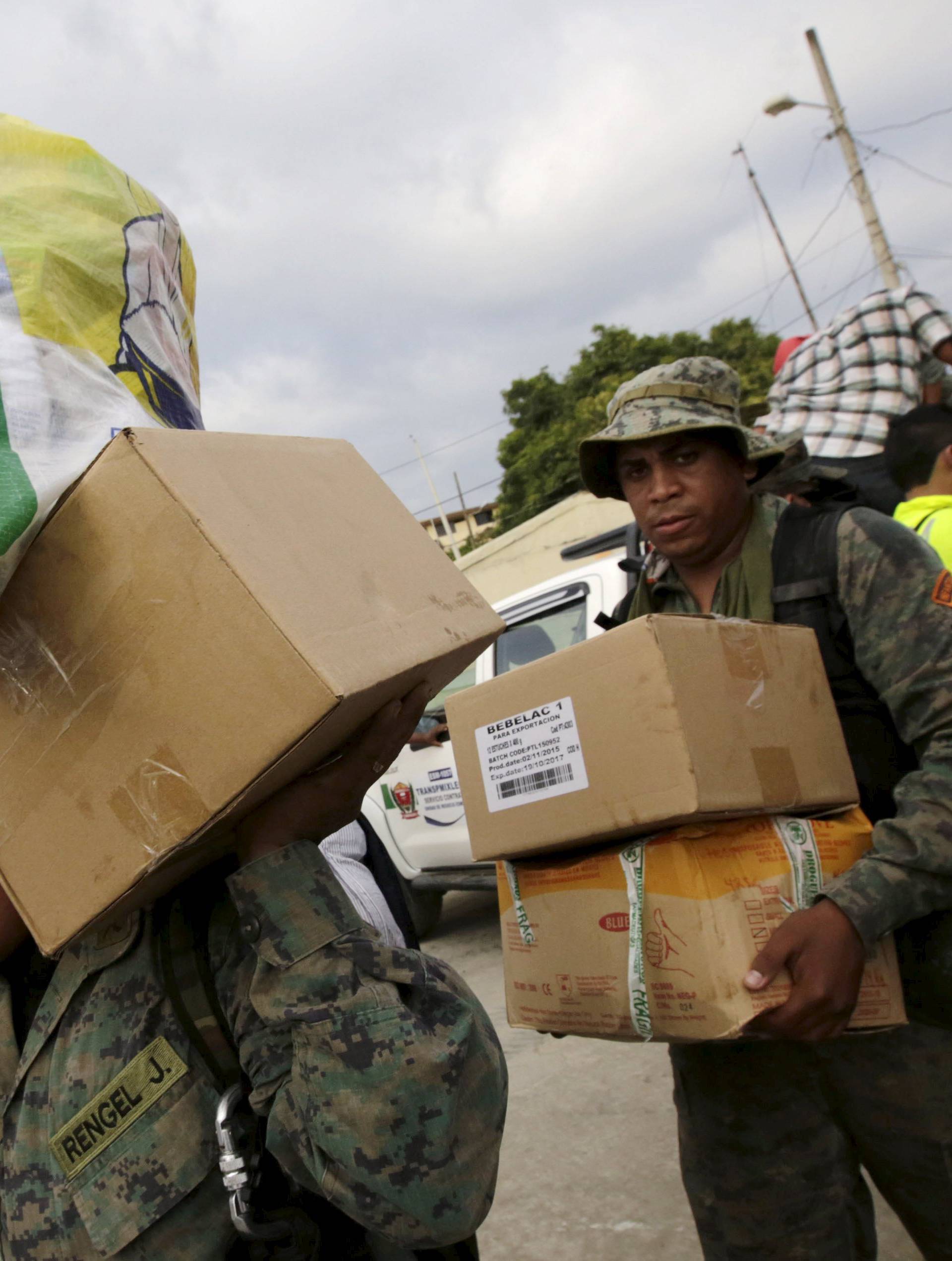 Soldiers load humanitarian aid boxes from a truck after an earthquake struck the town of Canoa