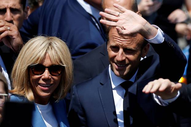 French President Emmanuel Macron waves to the crowd while touring Old Montreal with his wife Brigitte Macron in Montreal
