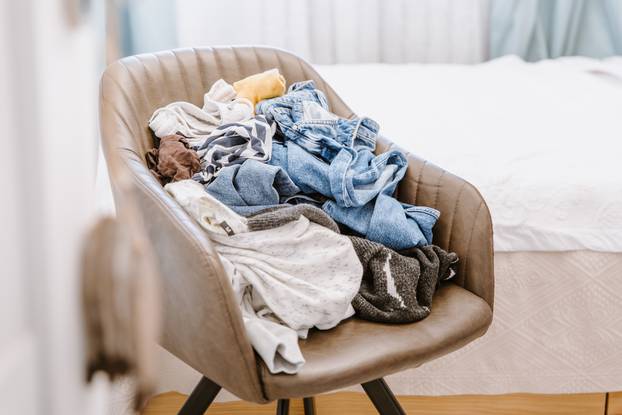 Pile,Of,Unfolded,Dirty,Clothes,For,Laundry,On,The,Chair.