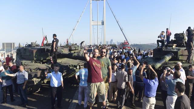 People take selfies after soldiers involved in the coup surrendered on the Bosphorus Bridge in Istanbul