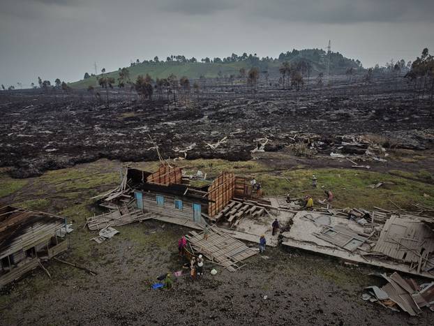 People prepare to evacuate from recurrent earth tremors as aftershocks after homes were covered with lava deposited by the eruption of Mount Nyiragongo near Goma