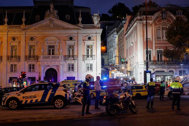 First responders work at the site of a funicular accident in Lisbon