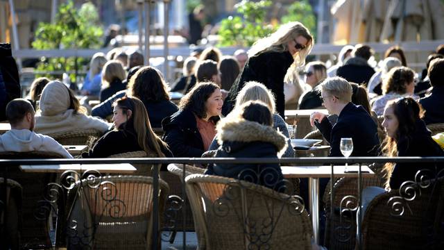 FILE PHOTO: People enjoy the sun at an outdoor restaurant, despite the continuing spread of the coronavirus disease (COVID-19), in Stockholm