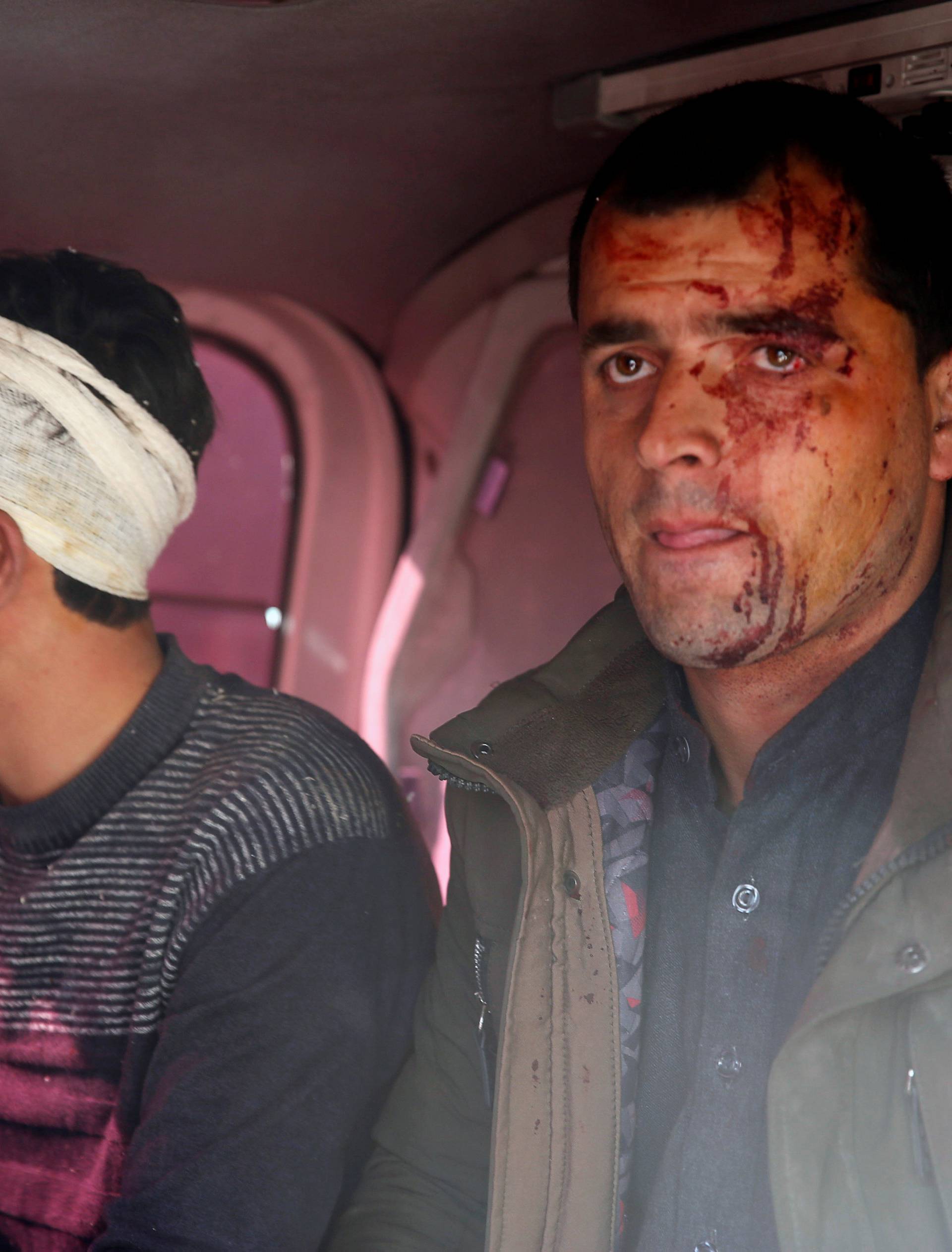 Injured men sit in an ambulance after a blast in Kabul, Afghanistan
