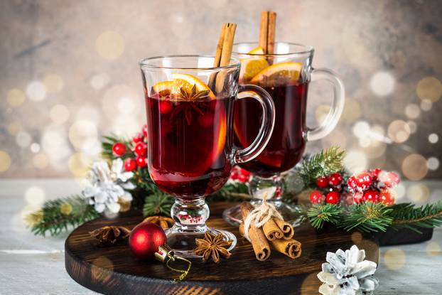 Mulled wine in glass mug with fruit and spices.