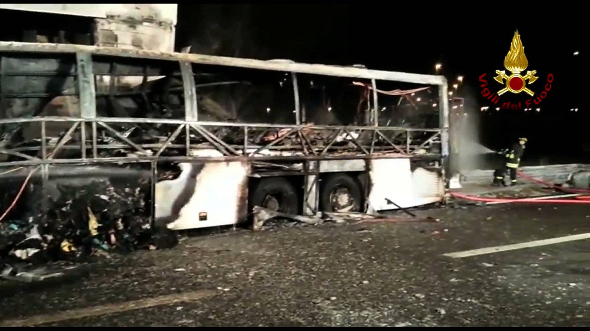 A still image taken from a video shows firefighters working next to a charred bus, which was carrying Hungarian students near Verona