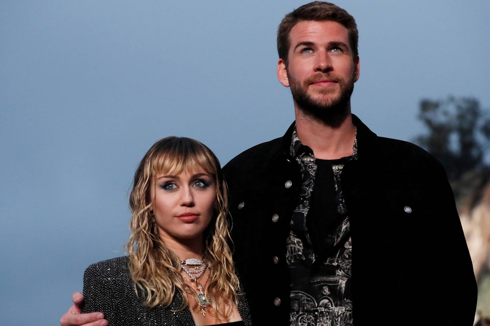 Miley Cyrus and Liam Hemsworth look on at the Saint Laurent Menâs Spring/Summer 2020 fashion show at Paradise Cove beach in Malibu
