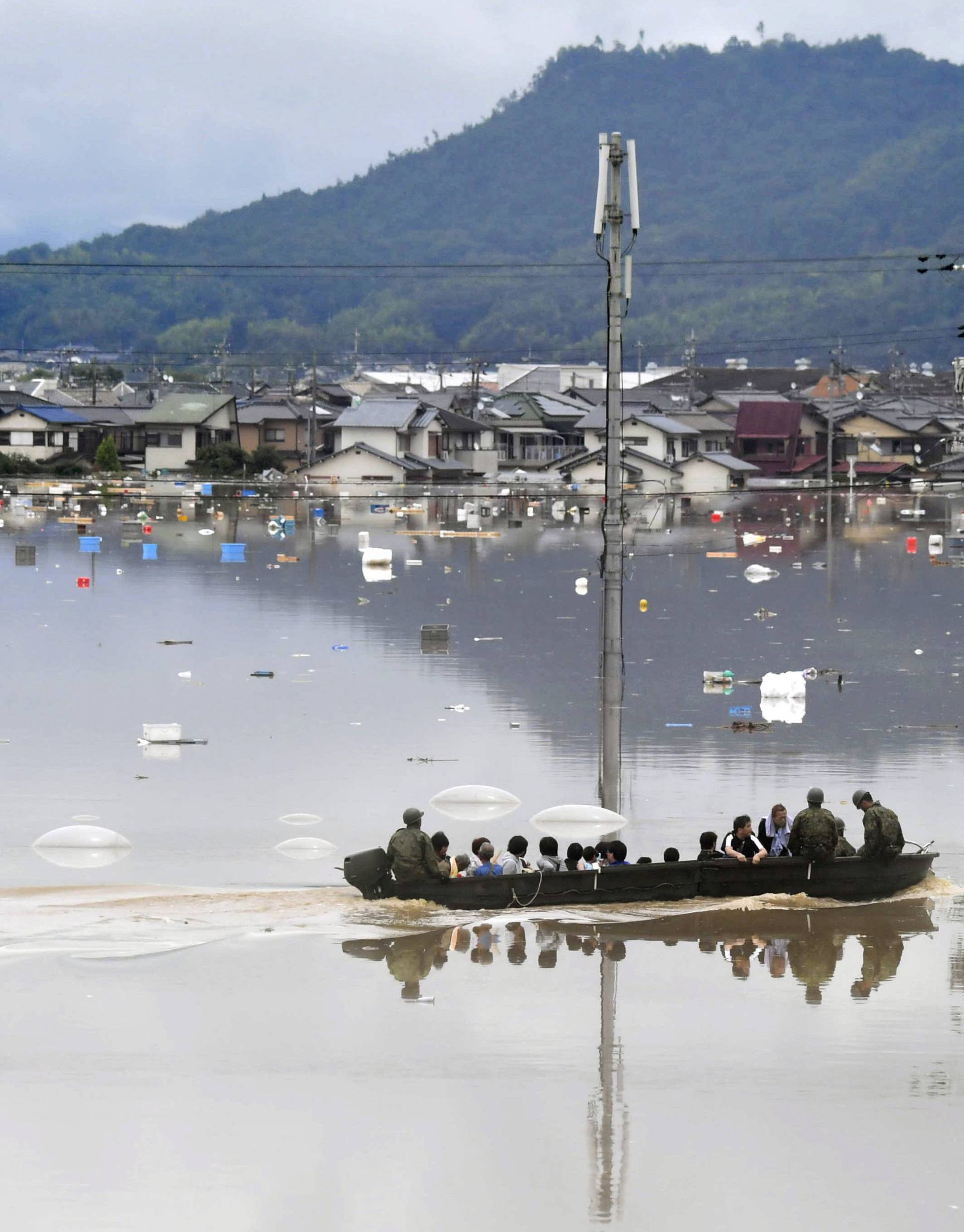 Residents are rescued from a flooded area by Japan Self-Defense Force soldiers in Kurashiki