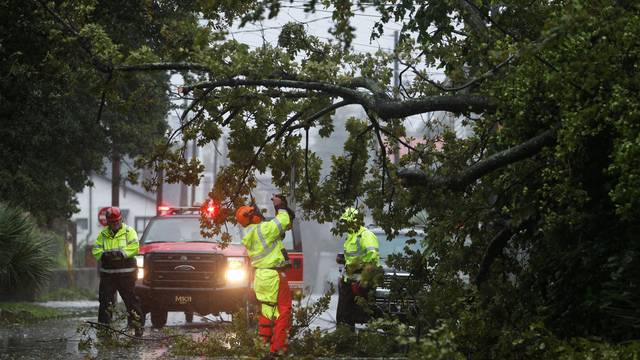 Crews with the Charleston Fire Department clear a fallen tree during Hurricane Dorian in Charleston