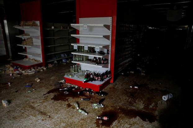 Damage is seen in a supermarket after it was looted during an ongoing blackout in Caracas