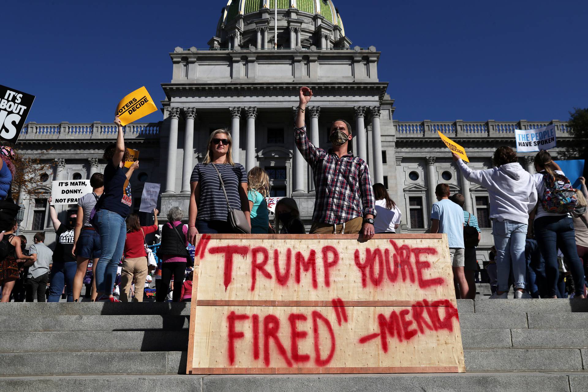 People react as media announce that Democratic U.S. presidential nominee Joe Biden has won the 2020 U.S. presidential election outside the State Capitol building, in Harrisburg, Pennsylvania