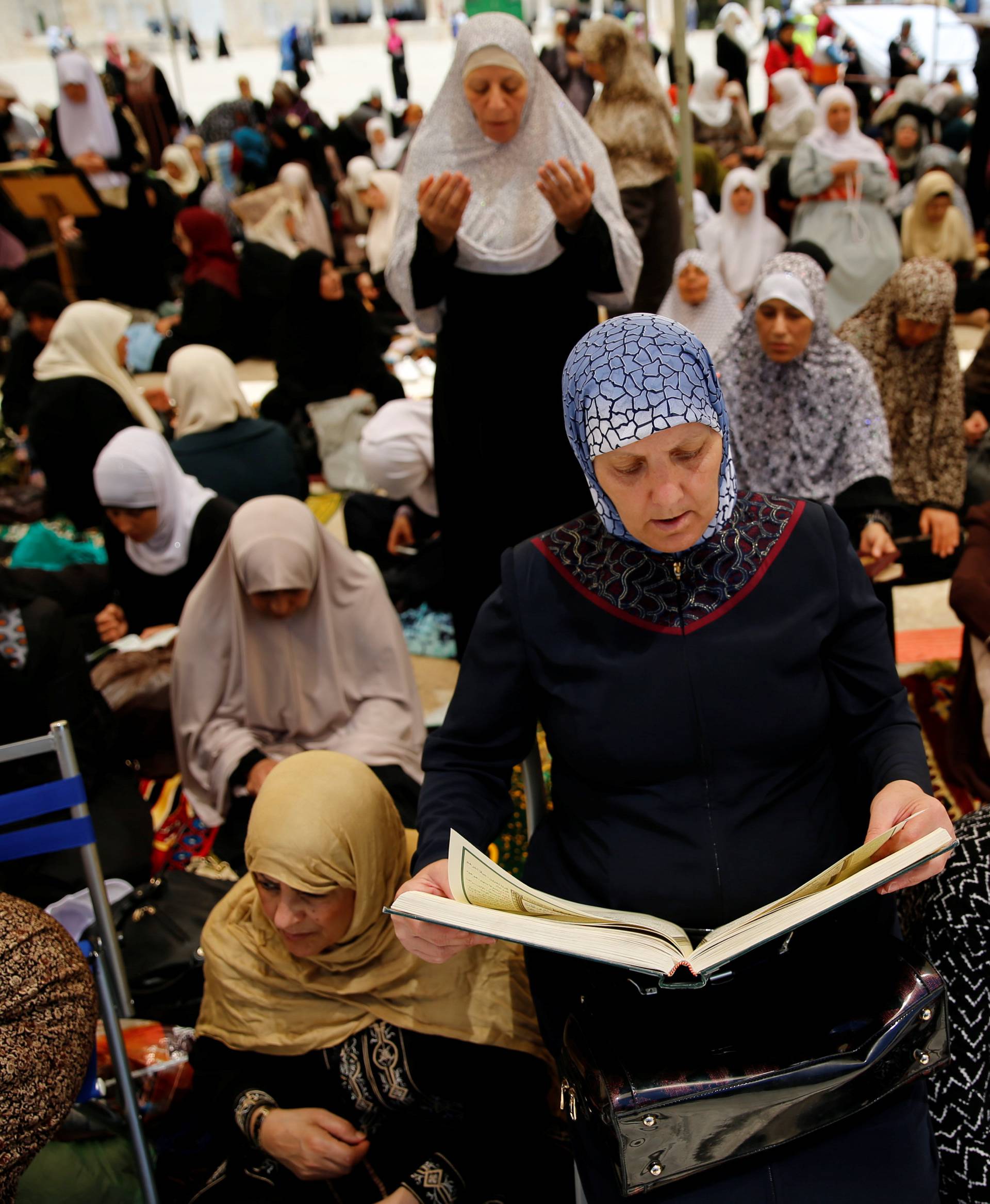 A Palestinian woman prays on the first Friday of the holy fasting month of Ramadan on the compound known to Muslims as Noble Sanctuary and to Jews as Temple Mount in Jerusalem's Old City