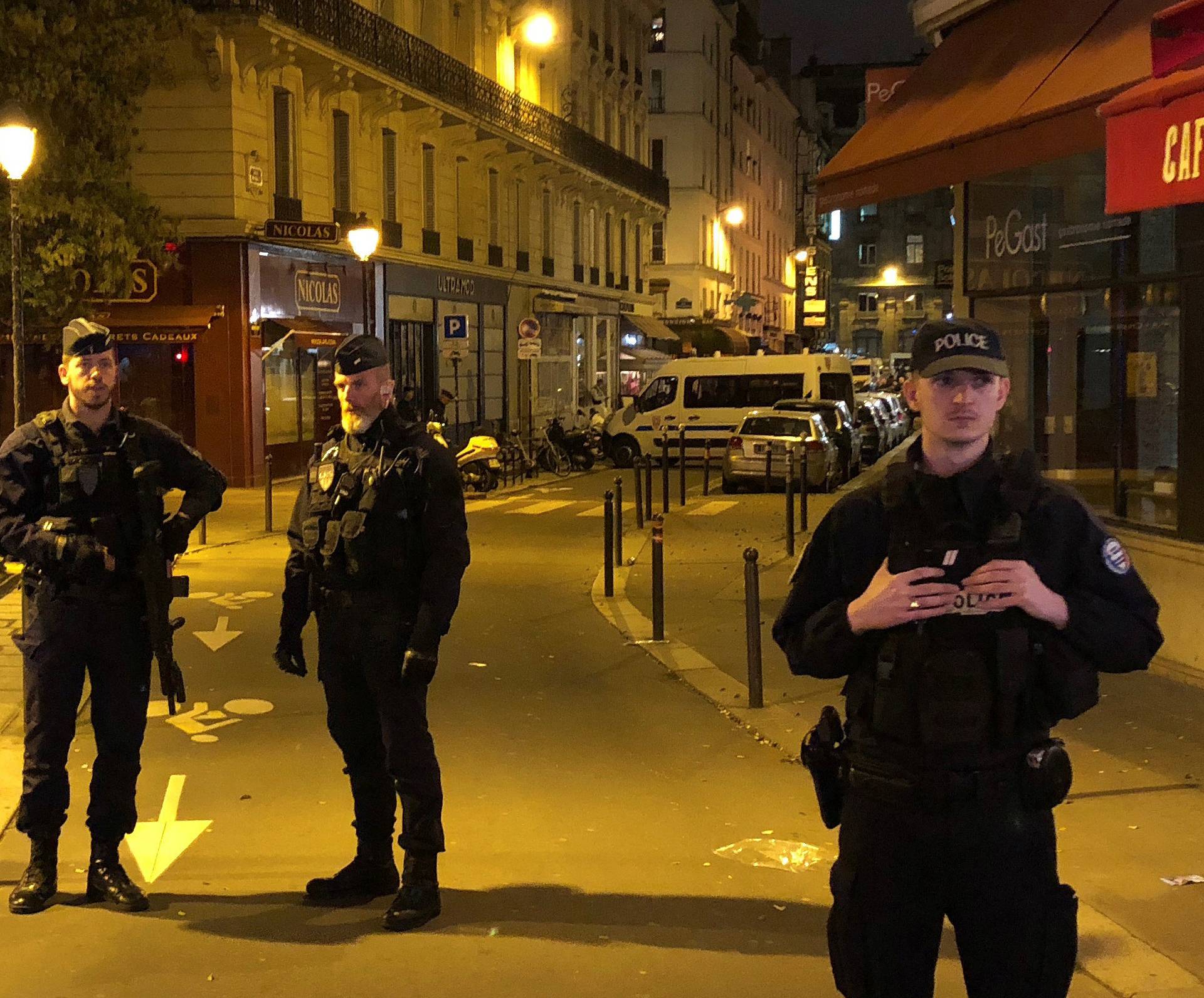 French police secure a street after a man killed a passer-by in a knife attack in the heart of Paris and injured four others before being shot dead by police