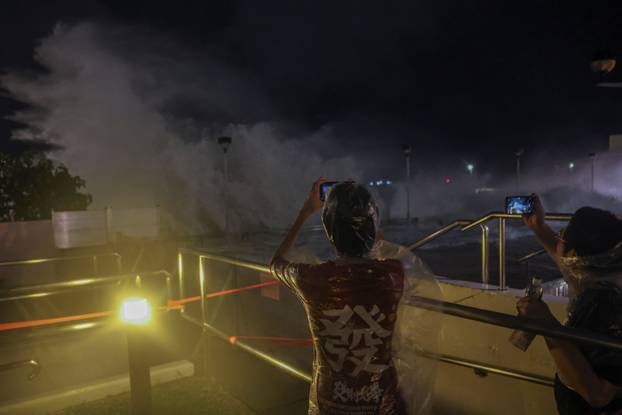 Residents watch rough waves from the shore before Super Typhoon Ragasa makes its closest approach to Hong Kong, in Hong Kong