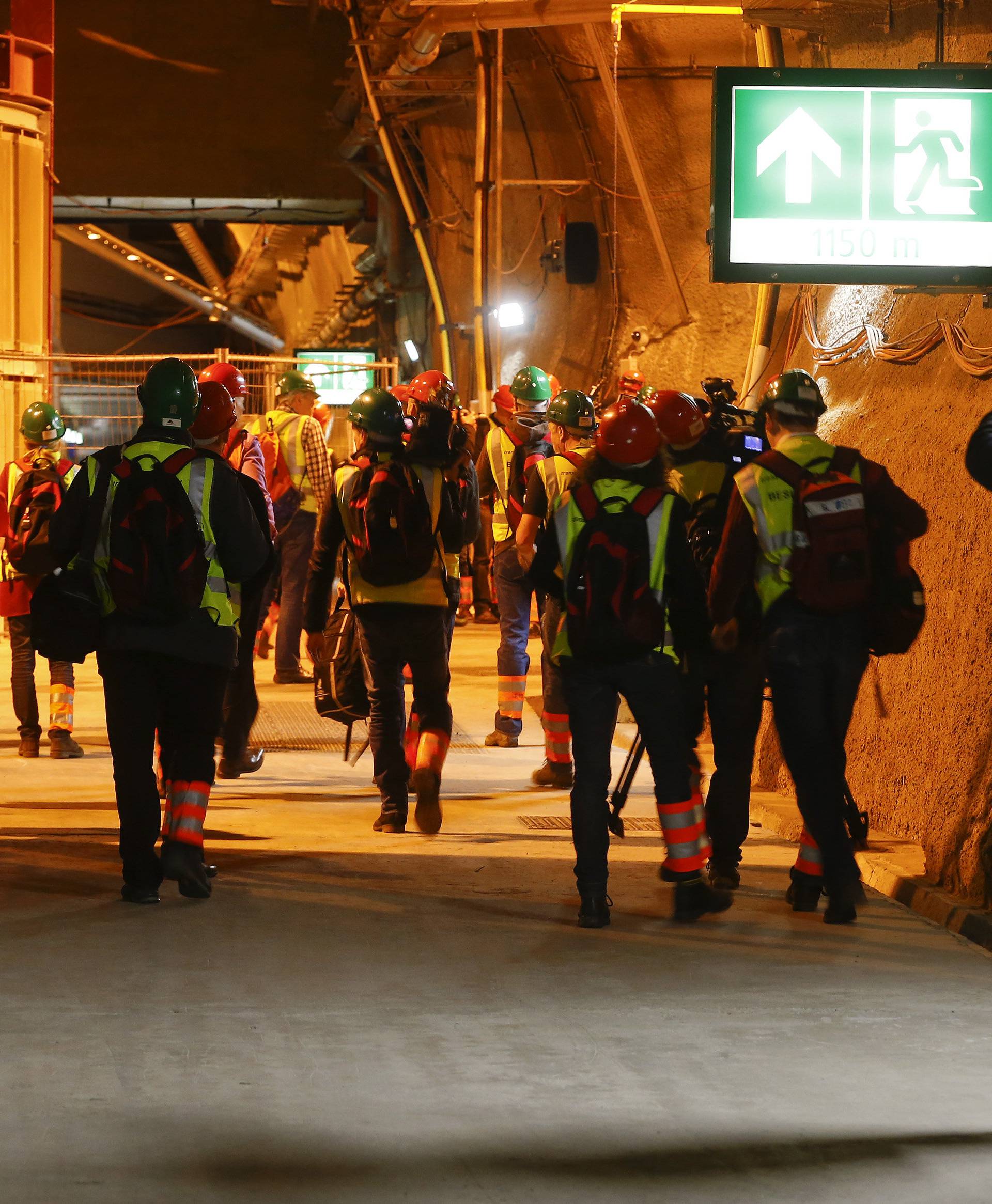 Journalists walk through an emergency tunnel at the NEAT Gotthard Base Tunnel near Sedrun