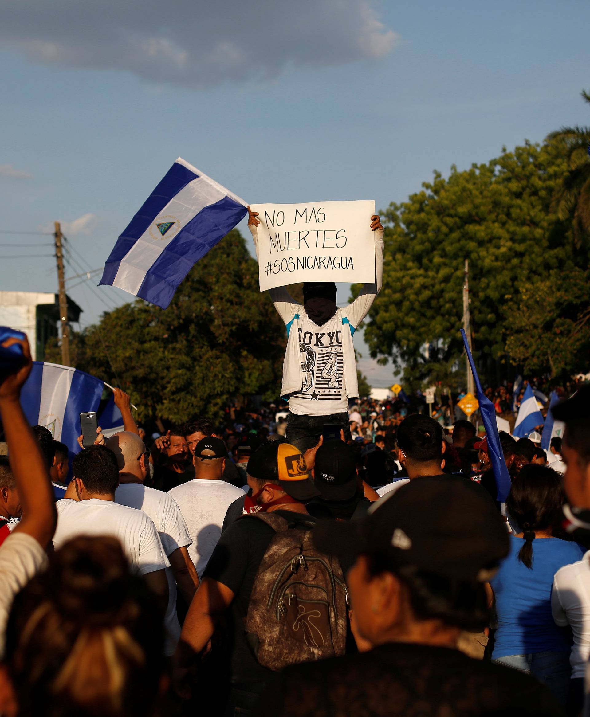 A demonstrator holds up a placard reading "No more deaths #SOSNicaragua" during a protest against police violence and the government of Nicaraguan President Daniel Ortega in Managua