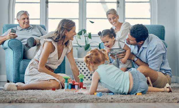 Family, grandparents and children play on carpet together and relax for learning, teaching and home language development. Happy family, mother and father with kids games or puzzle for mindset growth