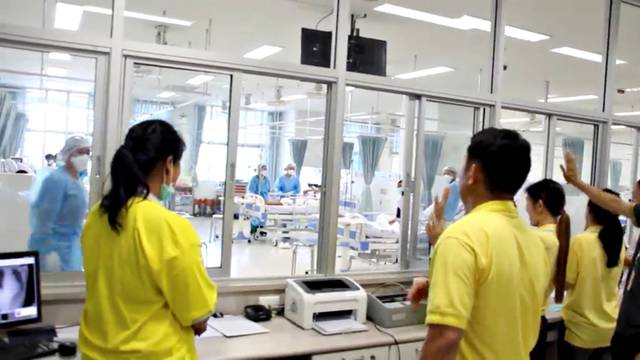 FILE PHOTO: A screen grab shows people looking through glass at the boys rescued from the Thai cave at a hospital in Chiang Rai