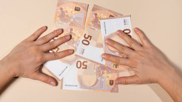 Human hands hold 50 euro banknotes on a beige background. Credit, corruption, bribery