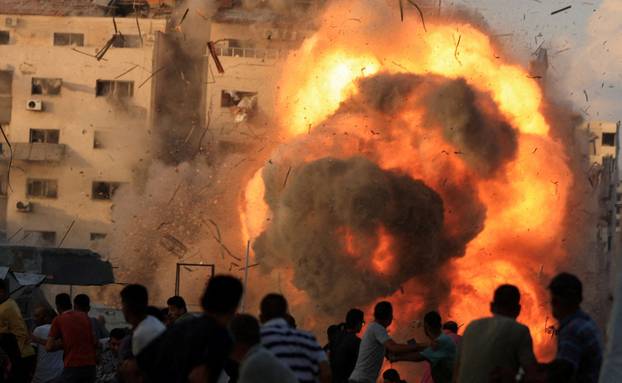 Smoke and flames rise as a residential building collapses after an Israeli air strike, in Gaza City