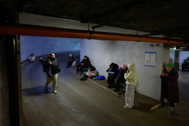 People take shelter inside an underground parking lot during a Russian missile and drone attack in Kyiv