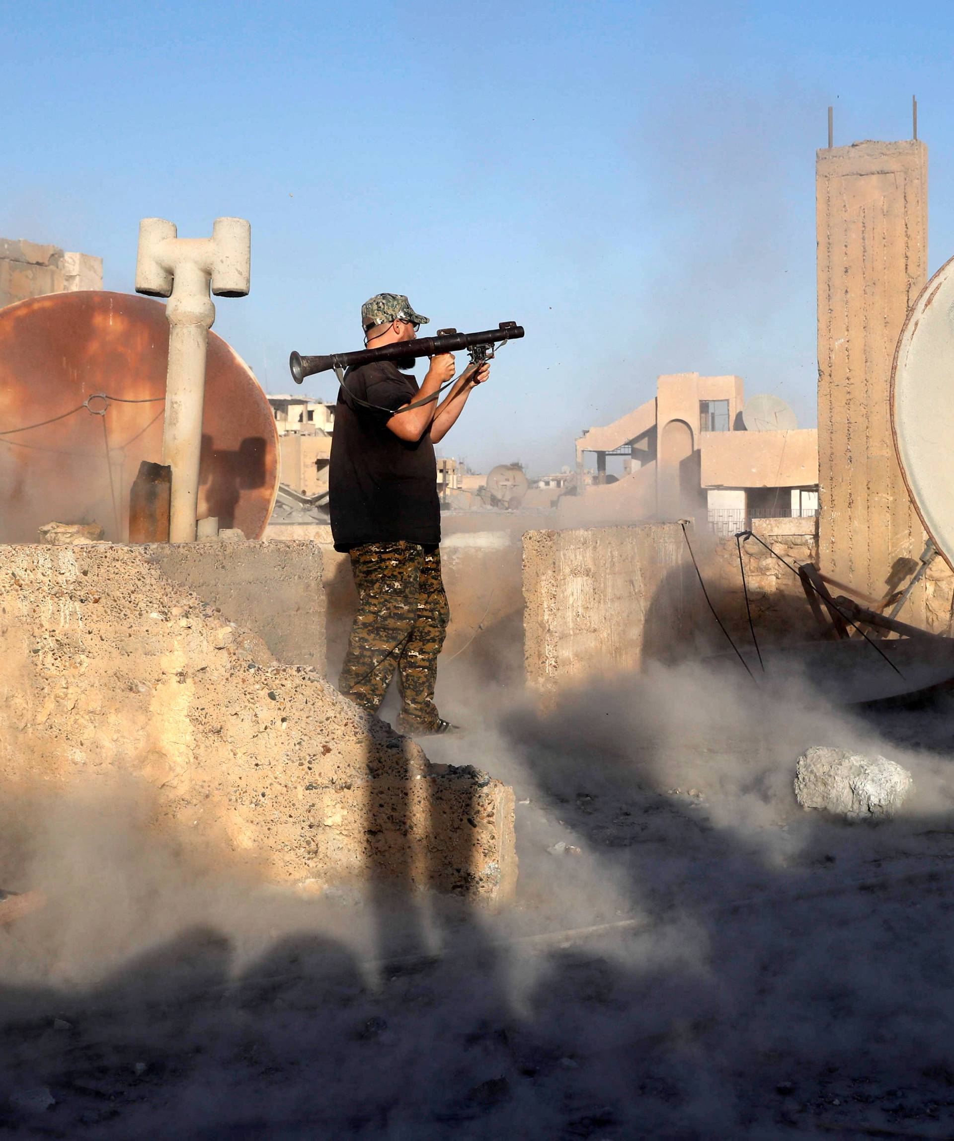 An American volunteer fighter of Syrian Democratic Forces fires an RPG during a battle with Islamic State militants at the frontline in Raqqa