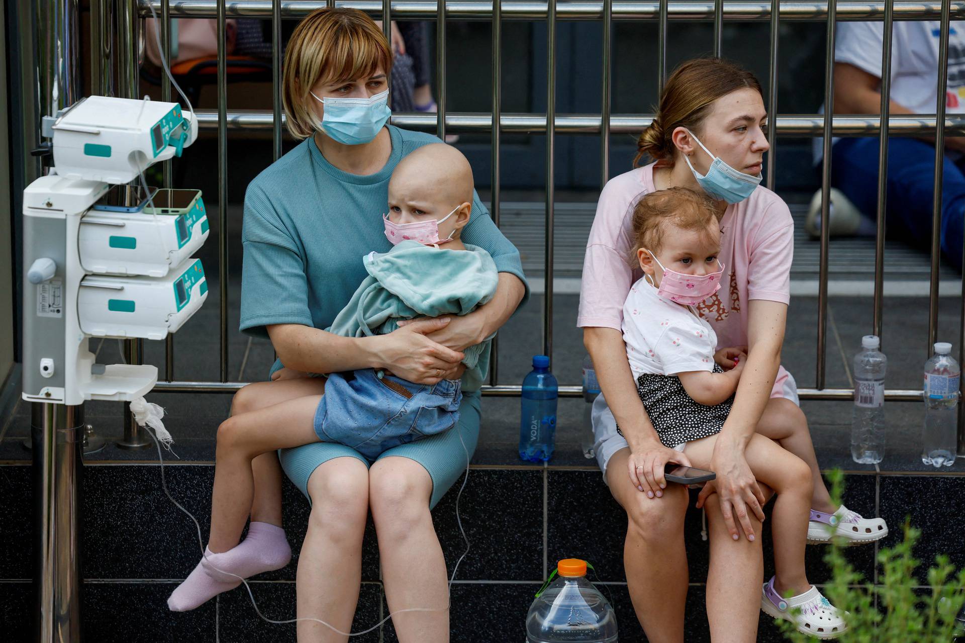 Women hold patients at Ohmatdyt Children's Hospital that was damaged during Russian missile strikes, in Kyiv