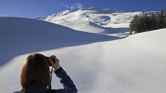 Tourist takes photos of snowy landscape