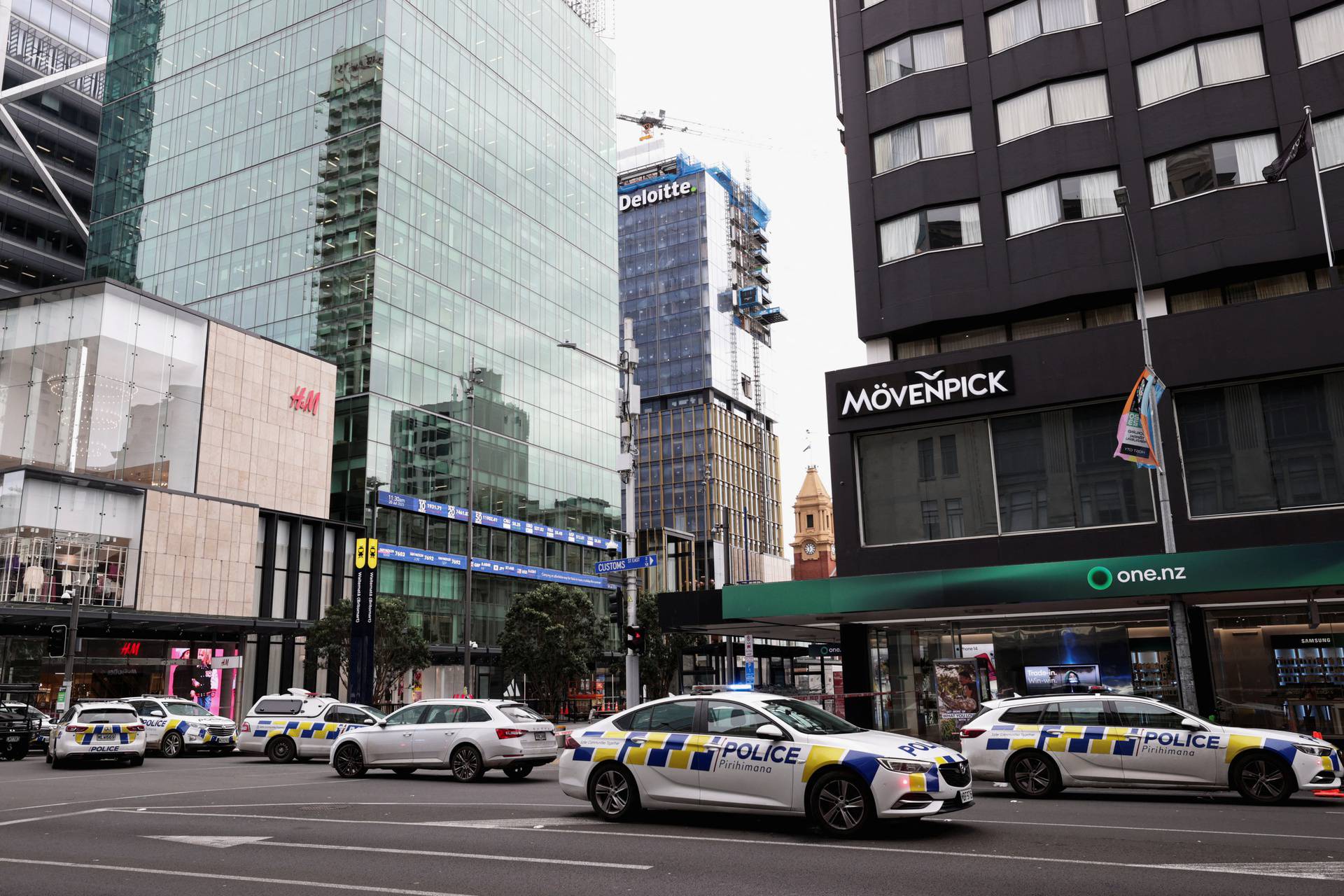 Police cars are seen near a construction site following a shooting in the central business district, in Auckland