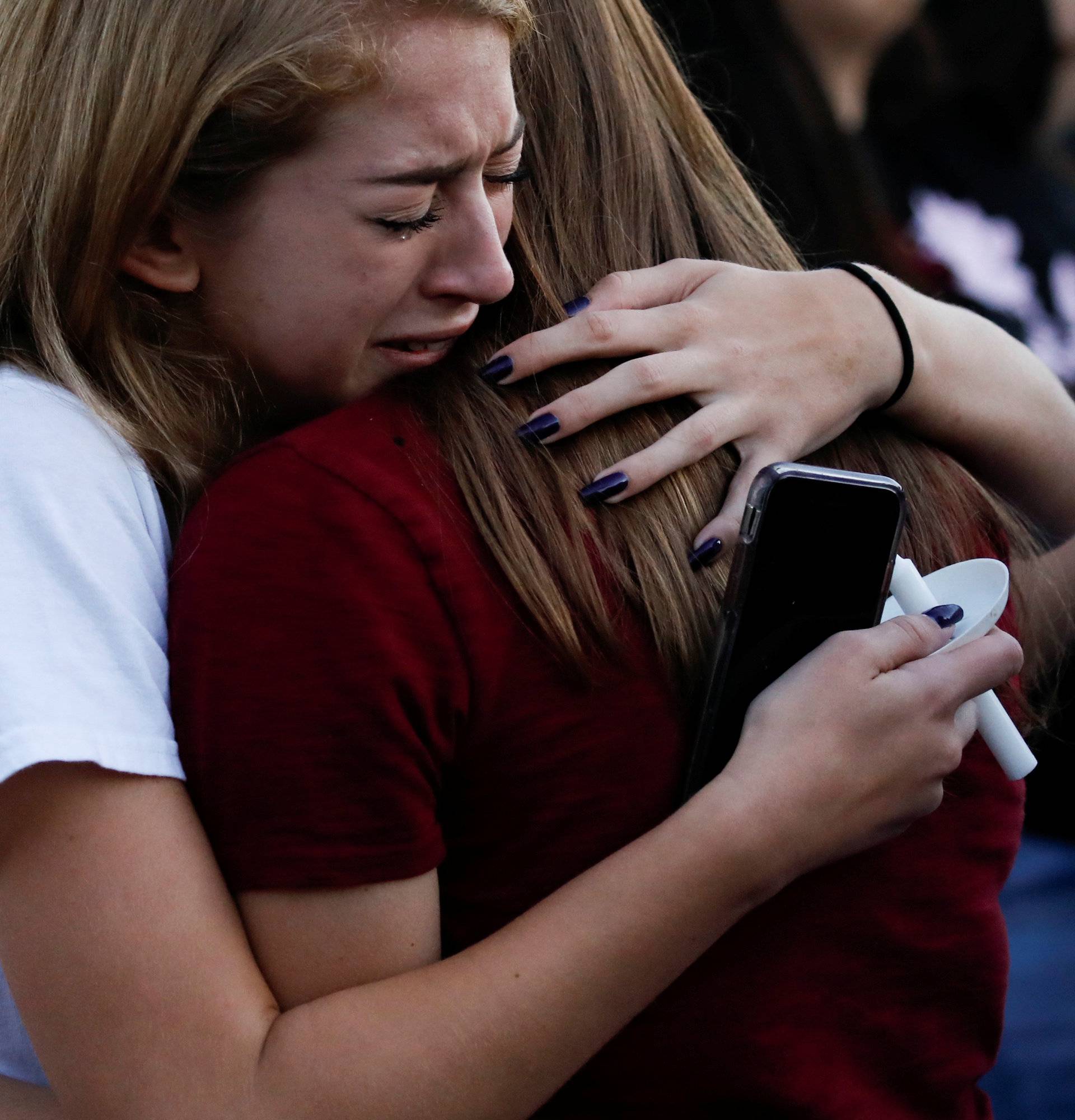 Students mourn during a candlelight vigil for victims of yesterday's shooting at nearby Marjory Stoneman Douglas High School, in Parkland