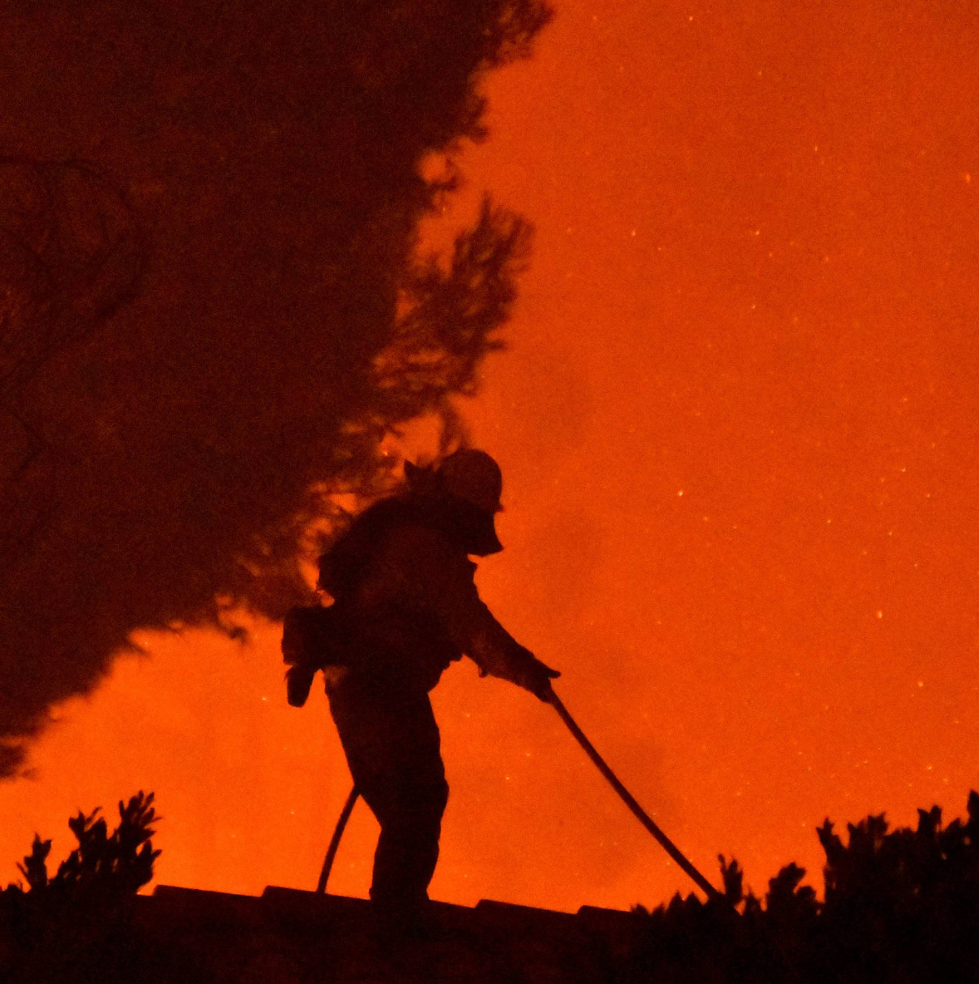 Firefighters battle a wind-driven wildfire called the Saddle Ridge fire in the early morning hours Friday in Porter Ranch
